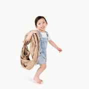 Sand@little girl holding folded tunnel